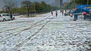 एक शहर में काले बादल, तेज हवा और बारिश का दृश्य, जहां सड़कें गीली हैं और मौसम खराब दिख रहा है।