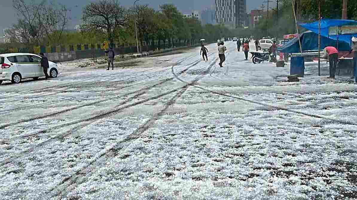 एक शहर में काले बादल, तेज हवा और बारिश का दृश्य, जहां सड़कें गीली हैं और मौसम खराब दिख रहा है।