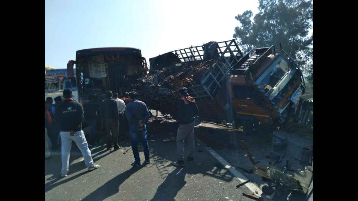 रात के समय हाईवे पर बस और ट्रक की टक्कर के बाद बचाव कार्य का दृश्य, जिसमें पुलिस और रेस्क्यू टीम लगी हुई है